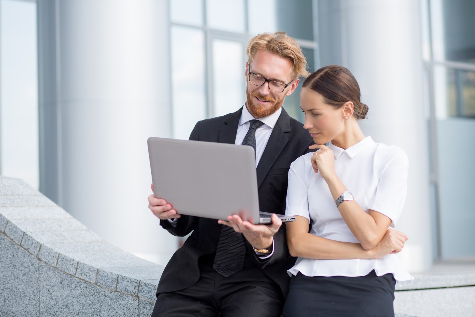 meeting-business-people-red-haired-man-glasses-keeping-laptop-showith-pretty-woman-smth-screen.jpg